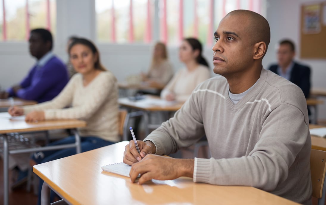 Hispanic man listening lecture during adult education class